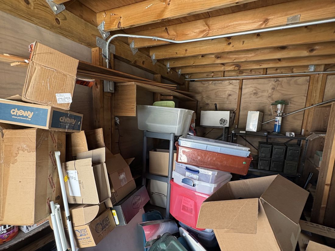 Detached garage filled floor to ceiling with boxes and equipment
