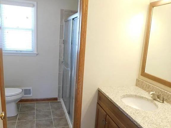 Updated bathroom with new vanity and tiled shower replacing the original pink suite