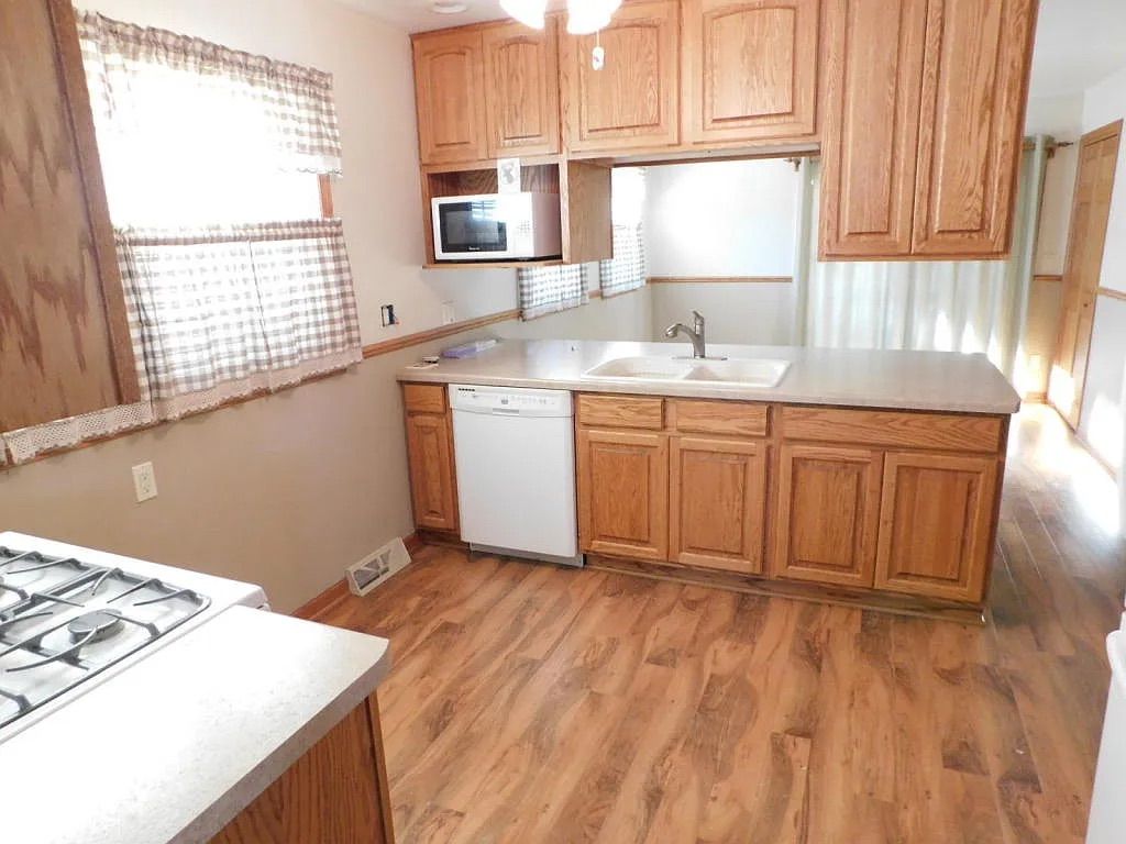 Updated kitchen with oak cabinetry, gas range and dishwasher in the Milwaukee, WI home