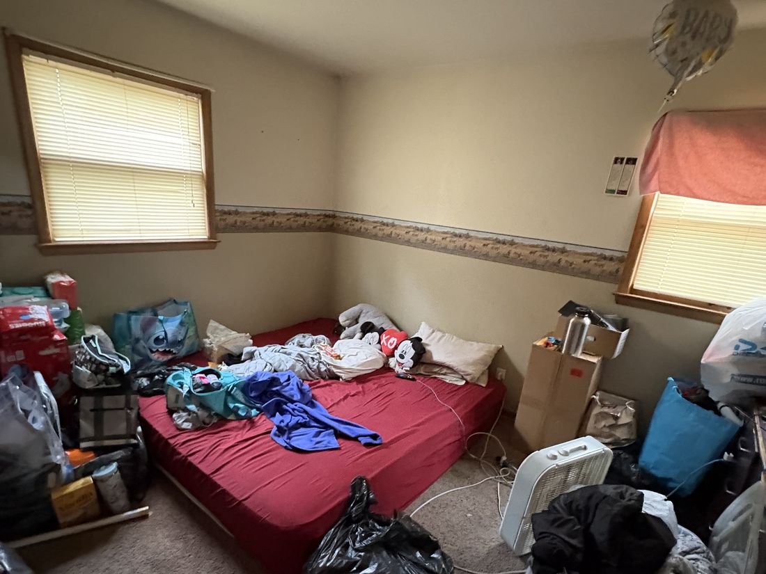 Bedroom filled with belongings before the move, in the Milwaukee converted duplex