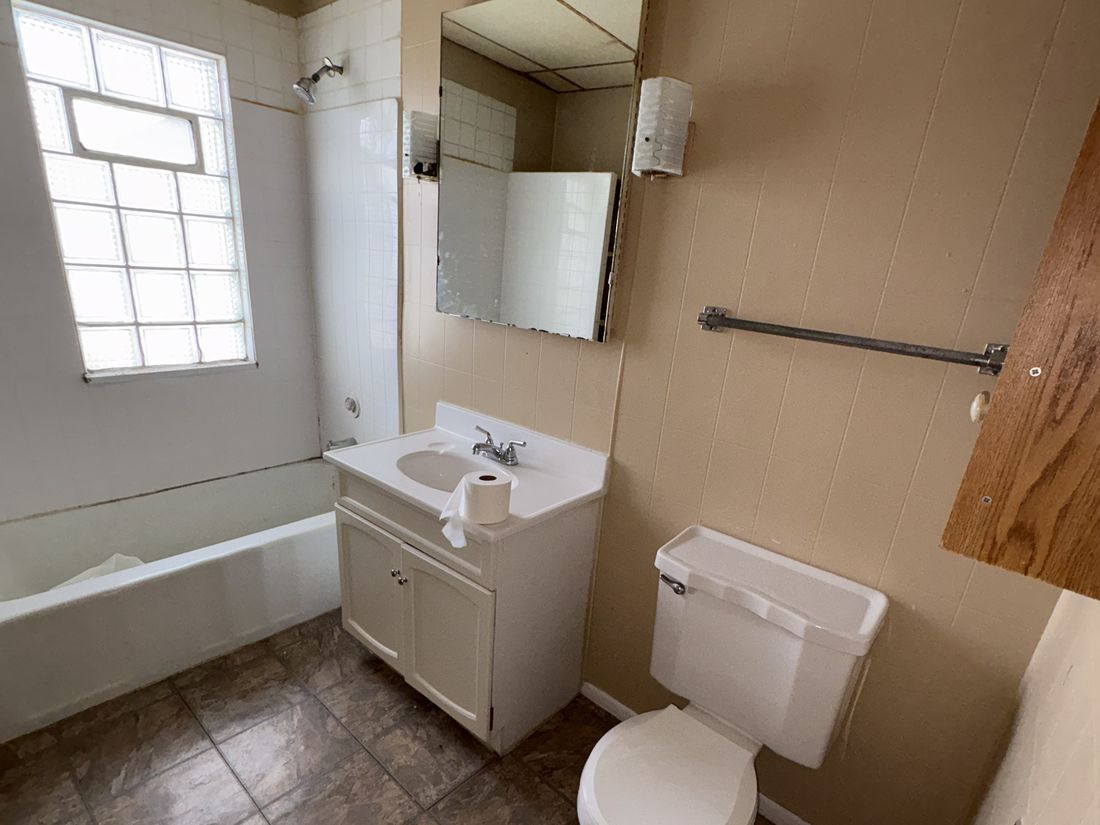 Second bathroom with glass block window and dated fittings in the West Allis duplex