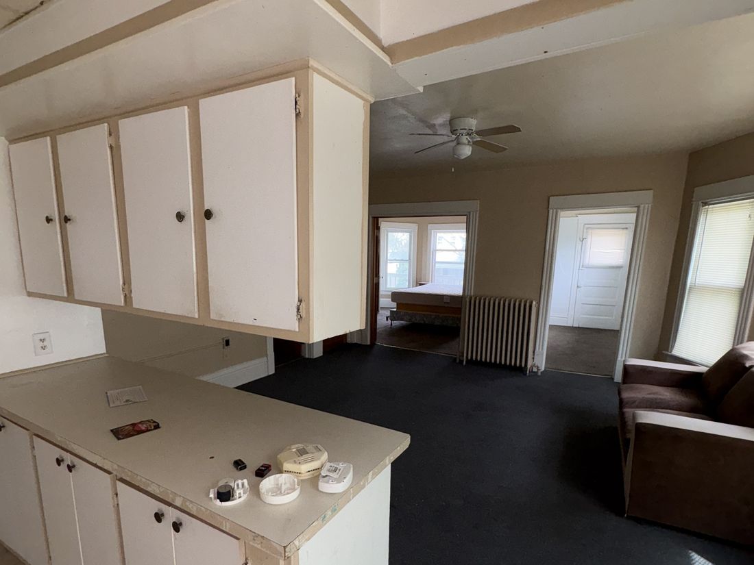 Lower-unit kitchen with dated cabinets and vinyl flooring in the West Allis duplex