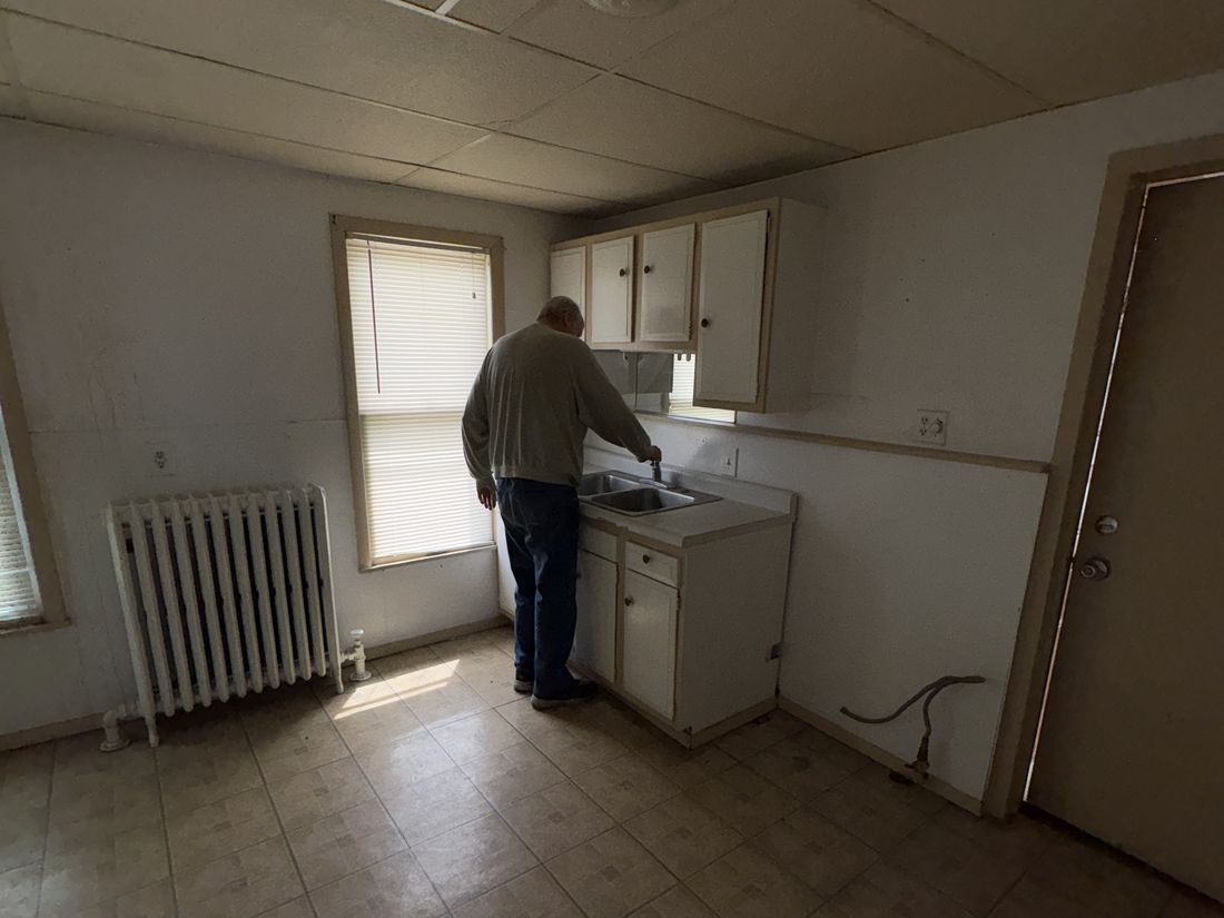 Cast-iron radiator in the West Allis duplex — the heating system behind the leak