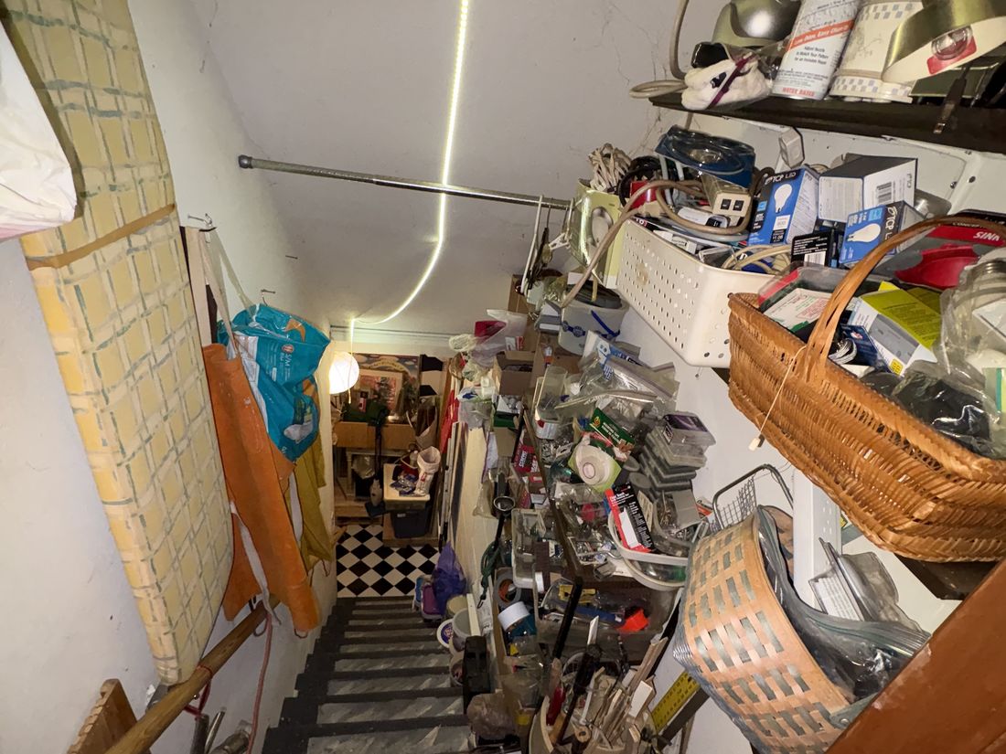 Basement stairway with stored items lining the descent in the West Allis duplex