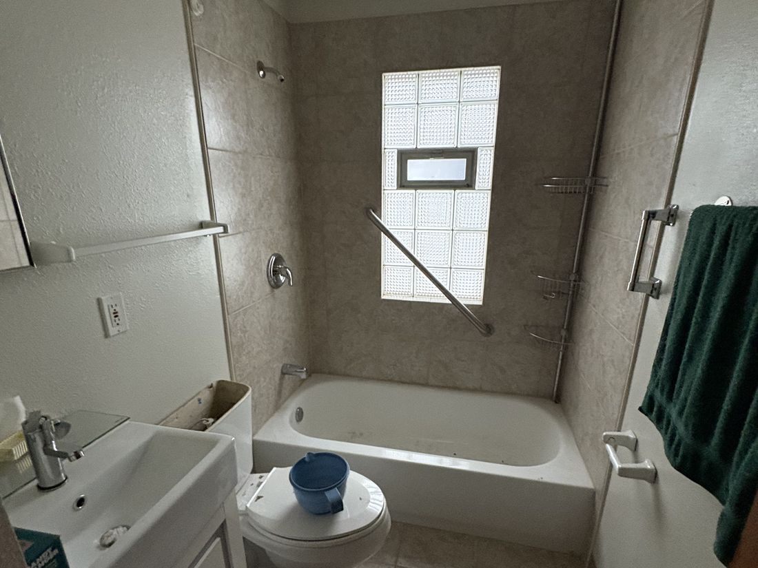 Original bathroom with tub and dated fittings in the West Allis estate property