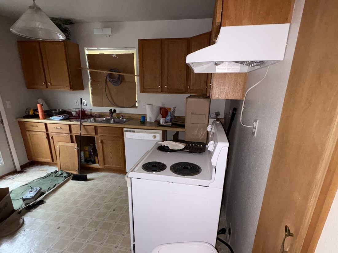 Lower-unit kitchen with dated cabinets and appliances in the West Allis, WI duplex